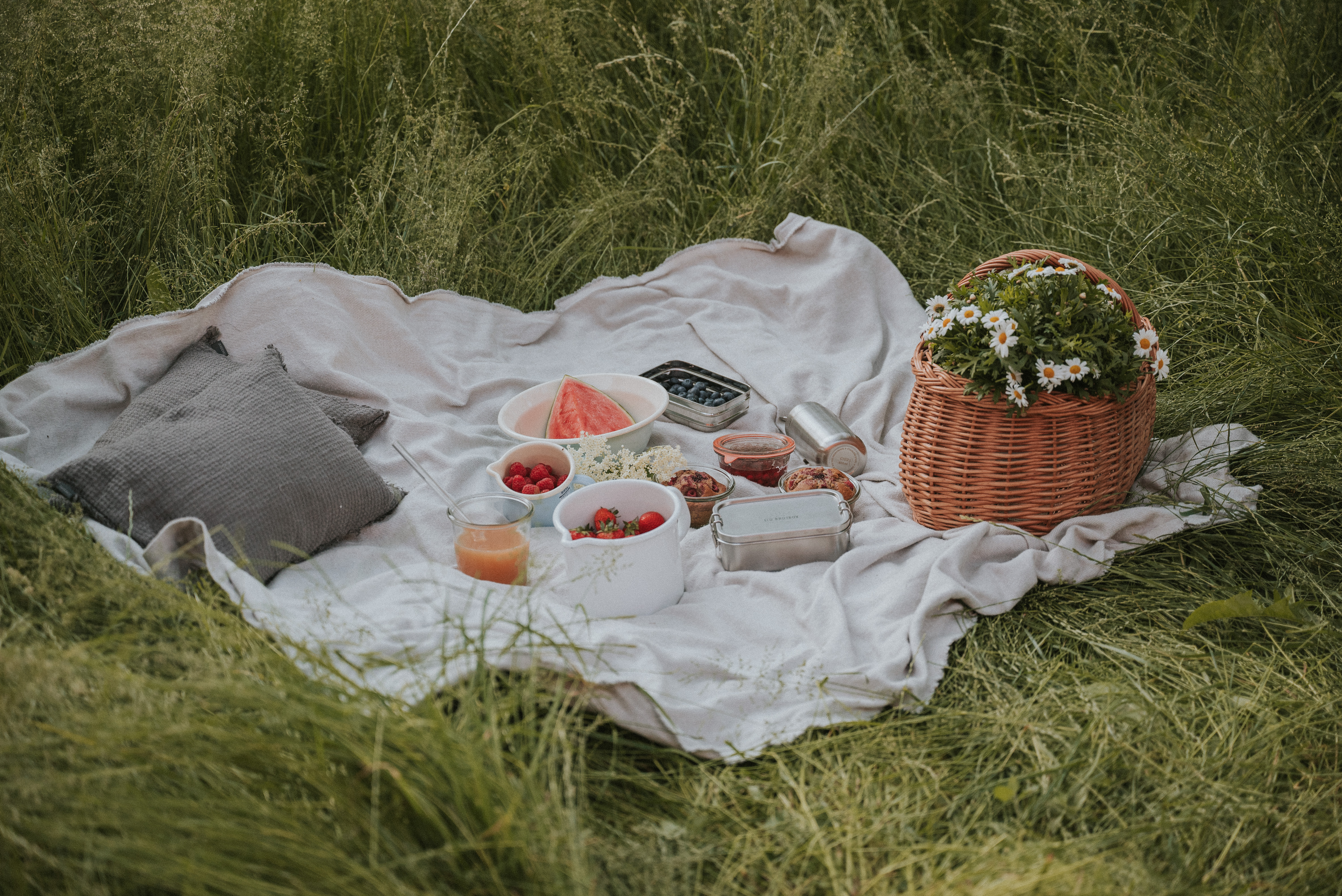 Müllfreies Picknick auf dem Land mit Korb und Emailleprodukten