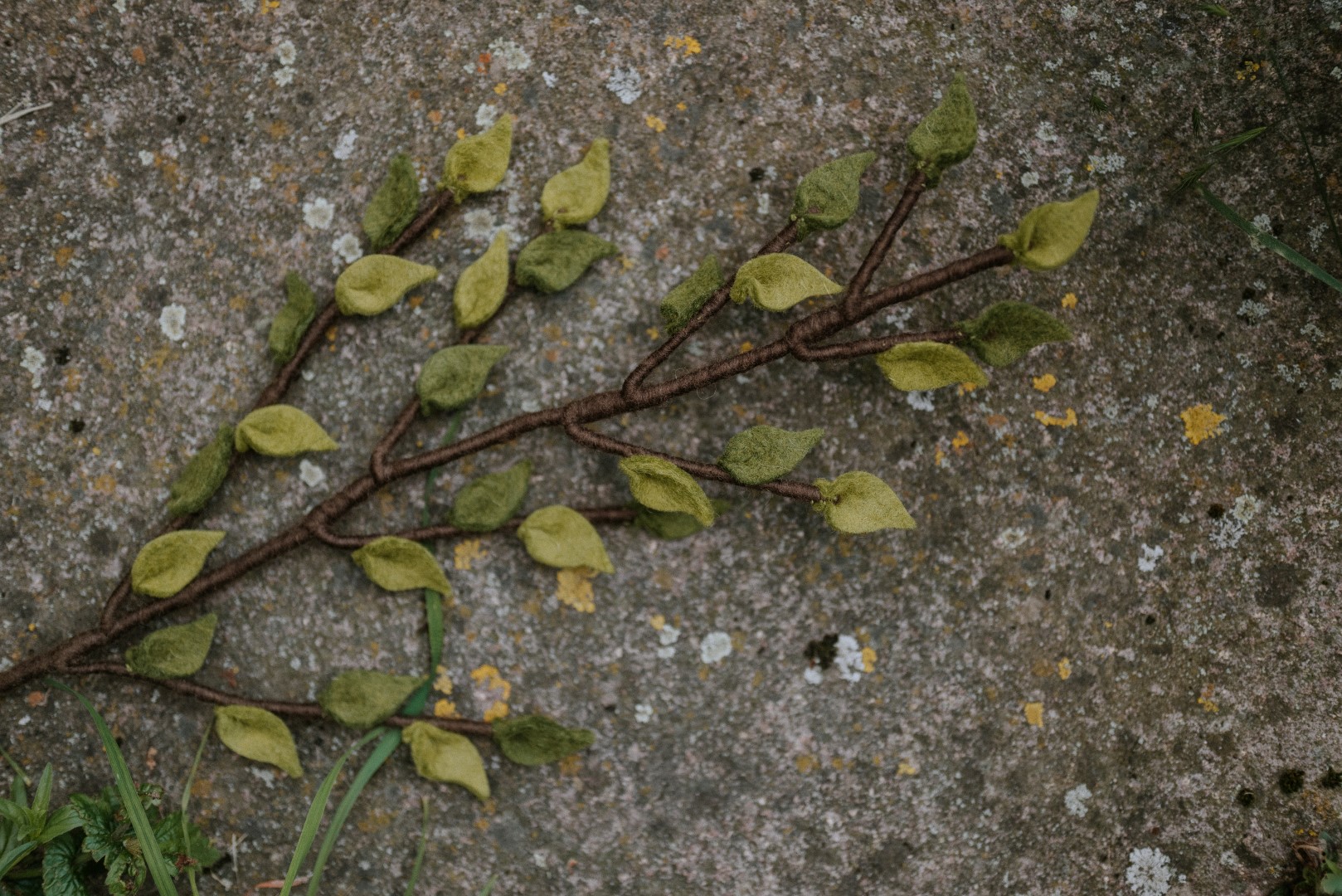 Zweig aus Filz mit grünen Blättern