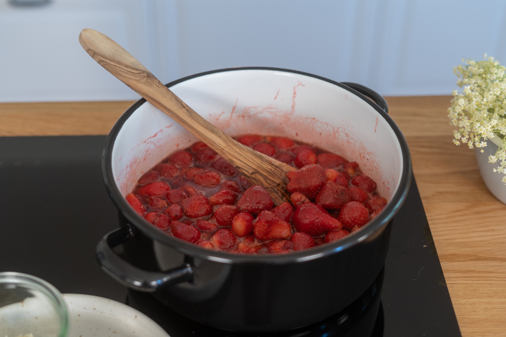 Erdbeer-Holunderblüten-Marmelade in der Verarbeitung im Kochtopf